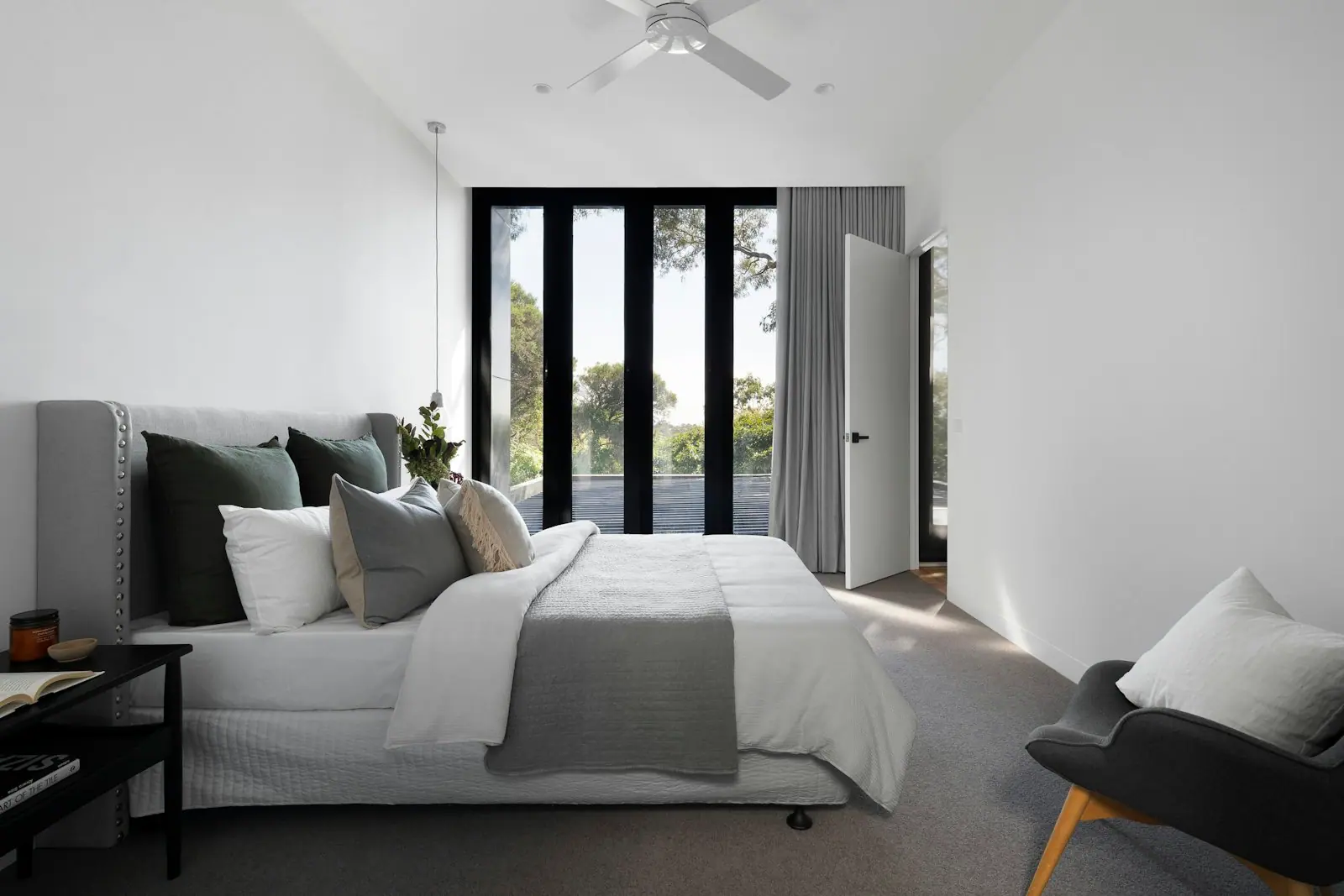 Calm bedroom with full-height glazed doors and soft grey furnishings