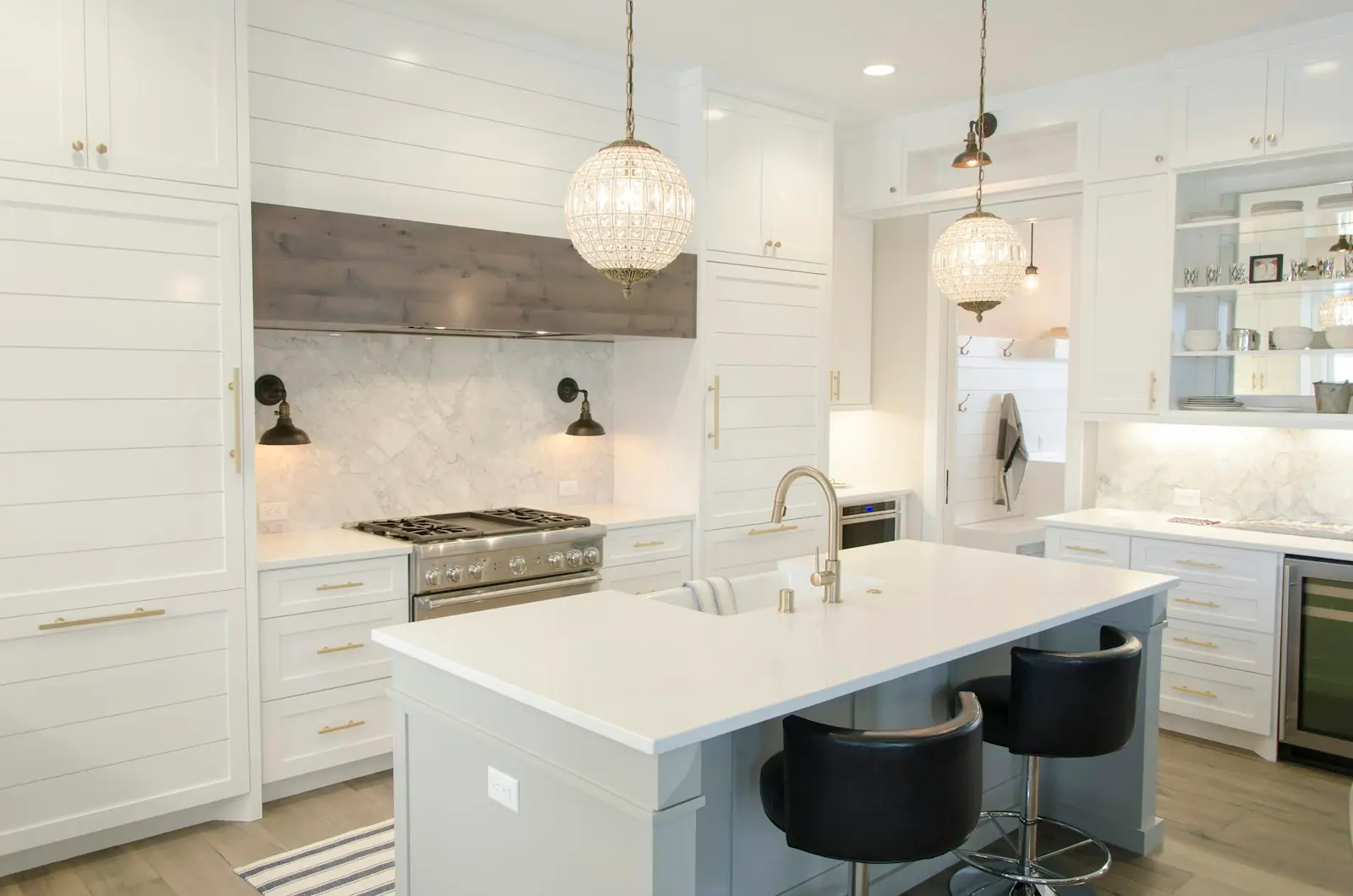 White shaker-style kitchen with a central island and pendant lights